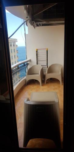 a room with a balcony with chairs and a television at mody appartment at alexandria in Alexandria