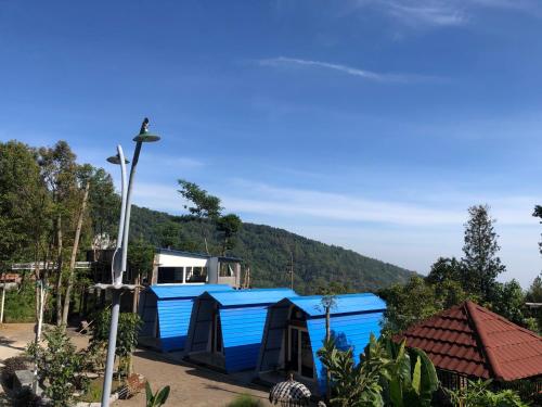 a blue shack with a mountain in the background at Bromo Camp House in Bromo