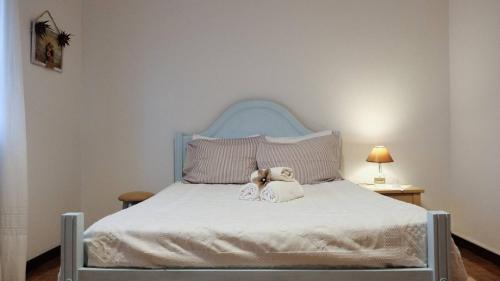 Dois ursos de peluche sentados em cima de uma cama em Casa das Flores em Santo Tirso