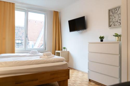 um quarto com uma cama e uma televisão na parede em Central living - Stephansdom Apartments em Viena