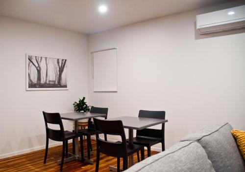 a dining room with a table and chairs and a couch at Whakatane B&B in Whakatane