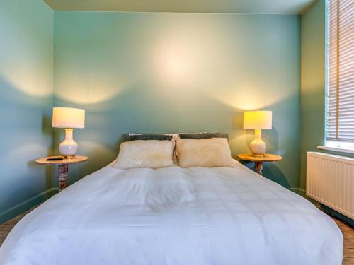 a bedroom with a large bed with two lamps at Luxurious holiday home in Heers with terrace in Mettekoven