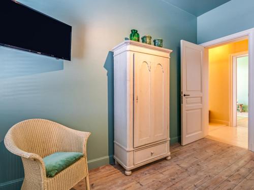 a room with a cabinet and a chair and a tv at Luxurious holiday home in Heers with terrace in Mettekoven
