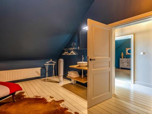a bedroom with blue walls and a bathroom with a sink at Luxurious holiday home in Heers with terrace in Mettekoven