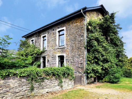 Une vieille maison en briques avec du lierre sur elle dans l'établissement Captivating Holiday Home in Lierneux with Garden, à Lierneux