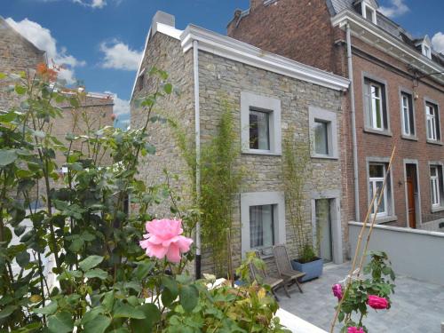 een bakstenen gebouw met een roze bloem ervoor bij Charming Holiday Home with Terrace in Tilff