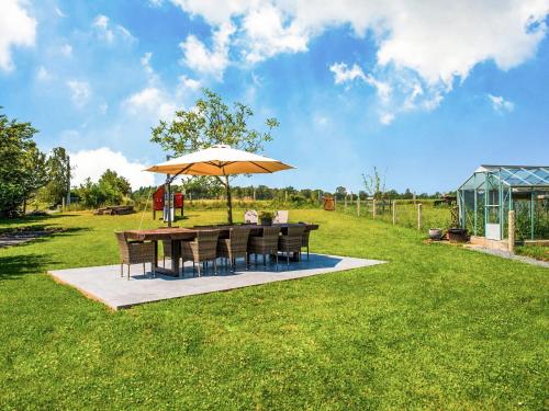 un tavolo e sedie sotto un ombrellone in un campo di Appealing villa in Bi vre with garden a Bièvre