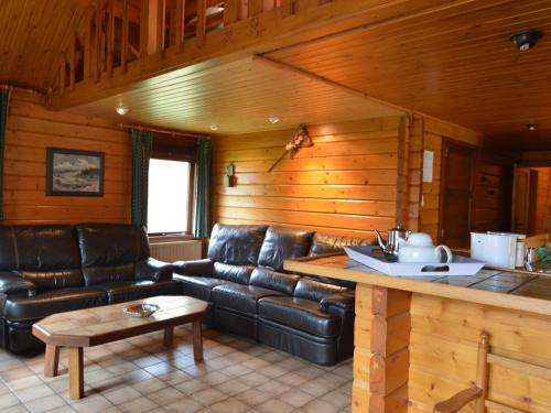 a living room with a leather couch and a table at Group Retreat in Robertville in Ovifat