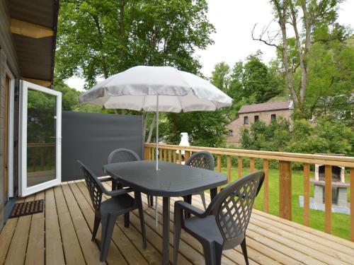 - une table avec des chaises et un parasol sur une terrasse dans l'établissement Chalet near Ourthe river and the city of Durbuy, à Vieuxville