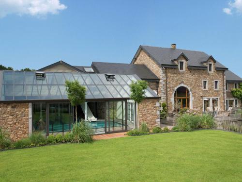 uma grande casa de tijolos com uma extensão de vidro em Holiday home in Theux with indoor swimming pool and wellness em Theux