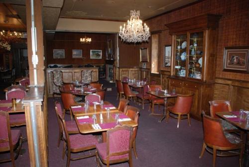 a restaurant with tables and chairs and a chandelier at Hotel Eklund in Clayton