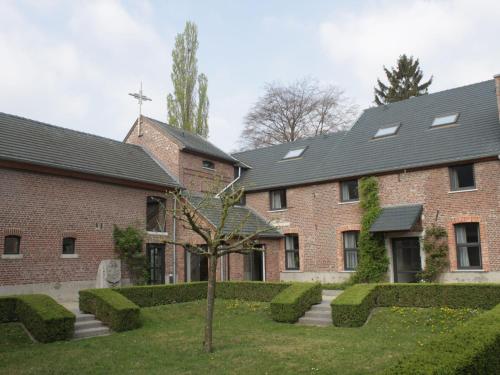 ein Backsteingebäude mit einem Baum im Hof in der Unterkunft Beautiful former monastery completely renovated in Sint-Truiden