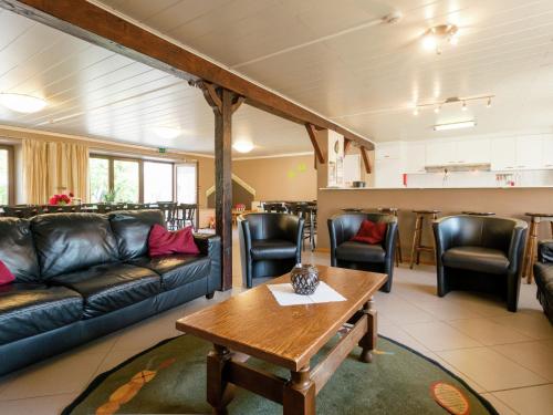 ein Wohnzimmer mit einem Sofa, einem Tisch und Stühlen in der Unterkunft Modern Cottage with Private Garden in Waimes in Weismes