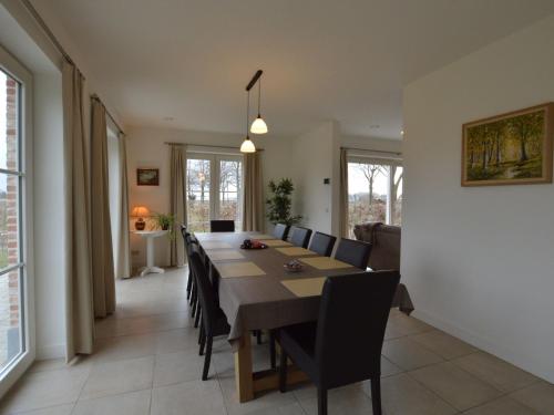 a dining room with a long table and chairs at Soothing Holiday Home with Recreation Room in Sint-Amands