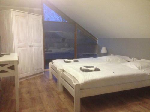 a bedroom with a white bed with slippers on it at Chalet with Valley Views, in Malmedy