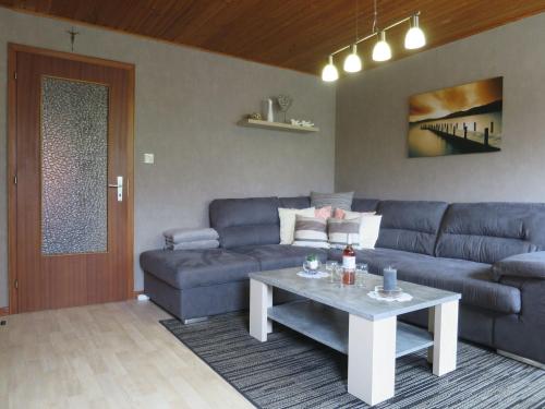 un soggiorno con divano blu e tavolo di Beautiful Apartment near Forest in Nidrum a Nidrum