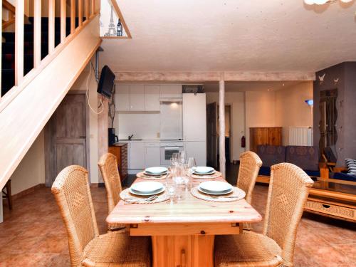uma mesa de madeira com cadeiras à sua volta numa cozinha em Charming holiday home in St Vith with terrace em Heuem