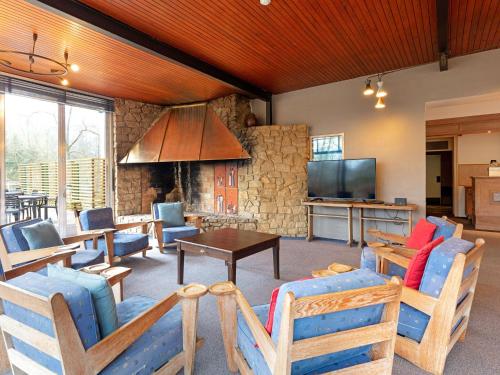 sala de estar con sillas, mesa y TV en Lavish Holiday Home in Fauvillers with Garden, en Fauvillers