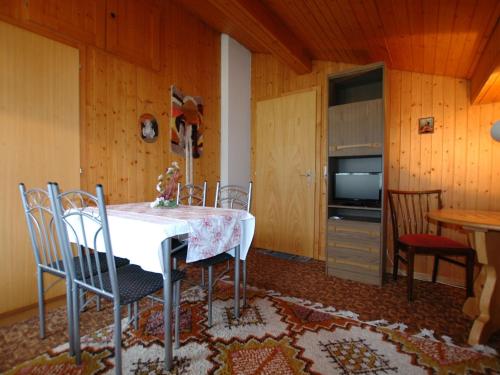 a dining room with a white table and chairs at Pristine home in a charming village large grassy sunbathing area view of the M nch and Jungfrau in Wilderswil