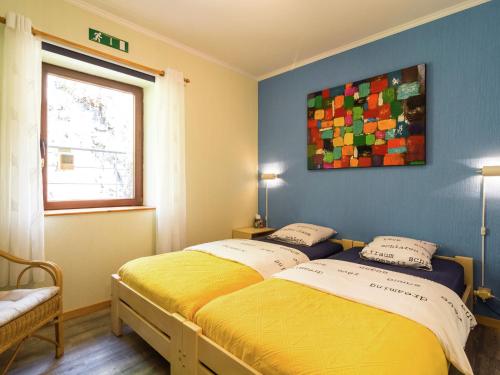 1 dormitorio con 2 camas y un cuadro en la pared en Lovely Holiday Home in Marcourt, en Marcourt
