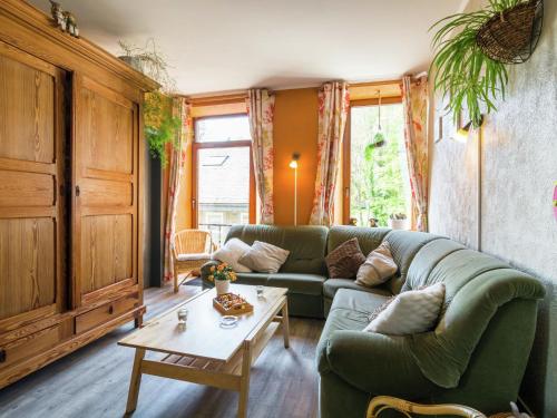 een woonkamer met een groene bank en een tafel bij Lovely Holiday Home in Marcourt in Marcourt