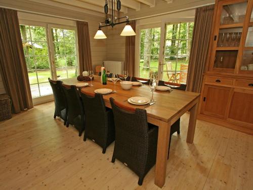 een eetkamer met een houten tafel en stoelen bij Countryside Chalet in Bomal sur Ourthe with Sauna Balcony in Bomal