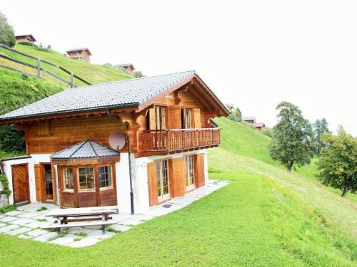 uma pequena casa de madeira numa colina relvada em Chalet in H r mence with Sauna Ski Whirlpool em Les Collons