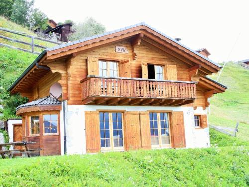 uma casa com uma varanda no topo de uma colina em Chalet in H r mence with Sauna Ski Whirlpool em Les Collons