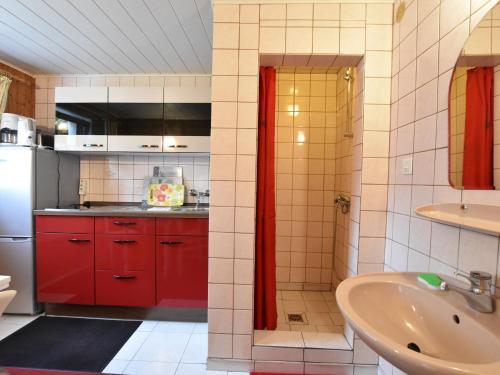 キュールングスボルンにあるComfortable Apartment in K hlungsborn with Parkingのキッチン(赤いキャビネット、シンク付)