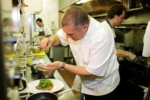 a man is preparing food in a kitchen at The Victoria in London
