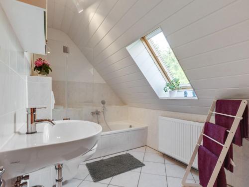 a bathroom with a sink and a tub and a window at Ruhiger Aufenthalt in der Naehe von Rostock in Kritzmow