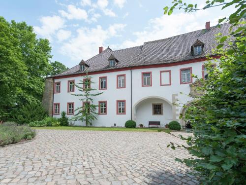 ein großes weißes Haus mit einer Kopfsteinpflastereinfahrt in der Unterkunft Vintage Apartment in Arzberg Triestewitz in Arzberg