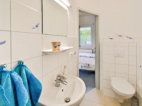 a white bathroom with a sink and a toilet at Wohnung nahe Ostsee Graal Müritz Strand in Rövershagen