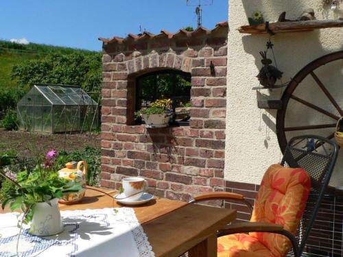 コルバッハにあるQuiet holiday home with terraceのパティオ(レンガ造りの暖炉、テーブル、椅子付)