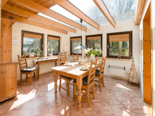 comedor con mesa, sillas y ventanas en Beautiful holiday home with garden, en Eichenborn
