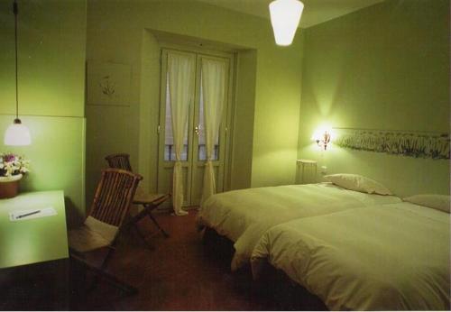 a green bedroom with a bed and a desk and a window at Hostal Fornos in Segovia