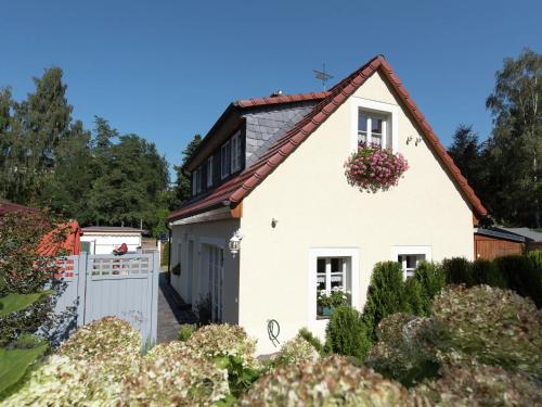 uma casa branca com um portão e uma cerca em Comfortable holiday home in Saxony with terrace em Oederan