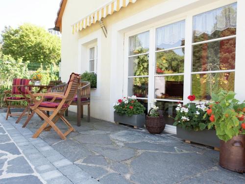 um pátio com uma mesa, cadeiras e flores em Comfortable holiday home in Saxony with terrace em Oederan