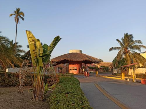 a resort with a building with a palm tree at Departamento Las Gaviotas in Acapulco