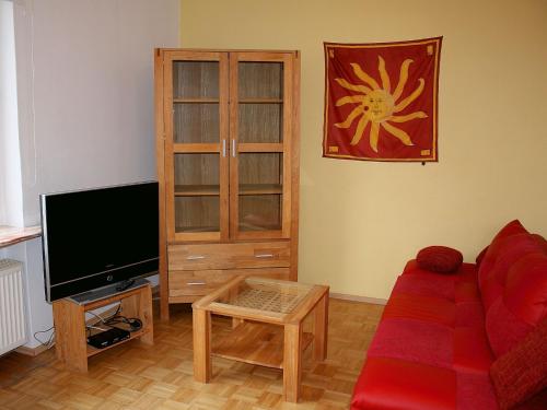 a living room with a red couch and a tv at Apartment with private terrace in H ddingen in Bad Wildungen