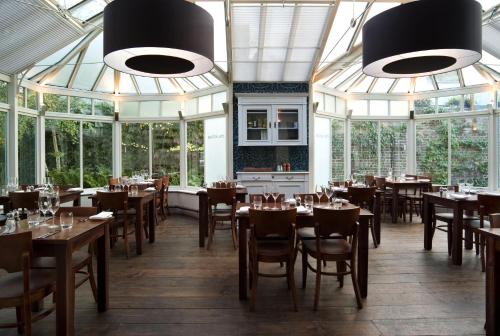 a dining room with tables and chairs and windows at The Victoria in London