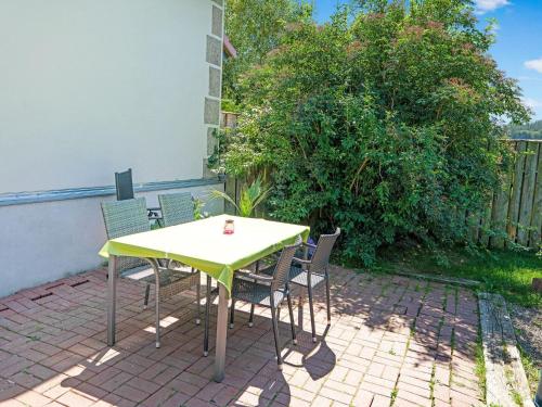 a yellow table and chairs on a brick patio at Stylish apartment in Stormbruch with garden in Stormbruch