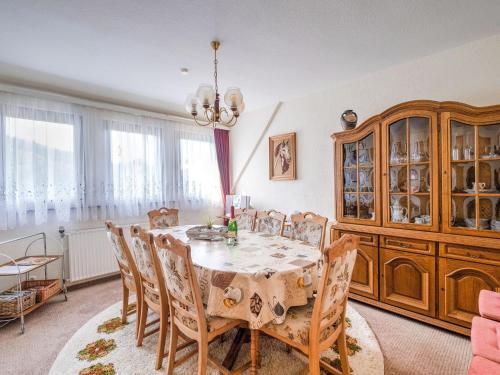 une salle à manger avec une table, des chaises et un lustre dans l'établissement Apartment with terrace in Sauerland region, à Medebach