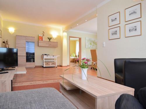 sala de estar con mesa y TV en Apartment in L wensen with private terrace, en Bad Pyrmont