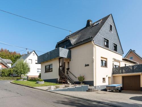 a white house with a black roof on a street at Apartment in Westerwald with private balcony 