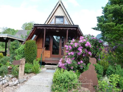 Cabaña pequeña con flores en un jardín en Cosy holiday home with garden in the Sauerland, en Medebach