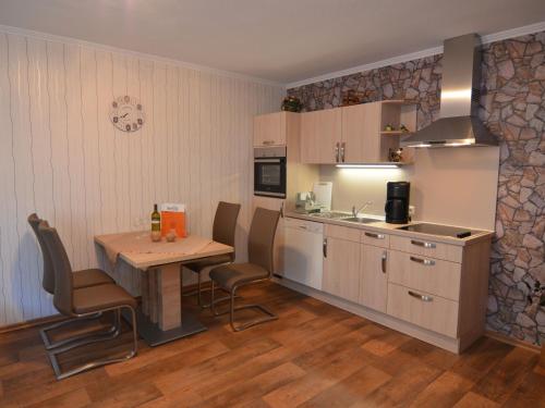 cocina con mesa y sillas y cocina con fregadero en Modern holiday home idyllic setting with terrace, en Medebach