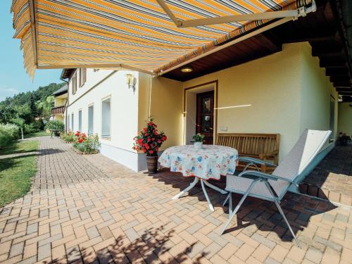 a patio with a table and chairs on a brick patio at Apartment near the forest in Plankenstein in Plankenfels