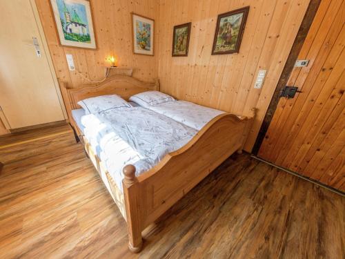 a wooden bed in a room with wooden floors at Idyllic holiday home with terrace in Hohenpeißenberg