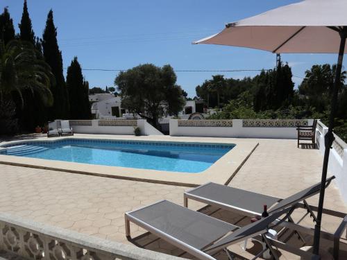 モライラにあるSpanish Villa in Moraira with Private Poolのスイミングプール(椅子2脚、パラソル付)
